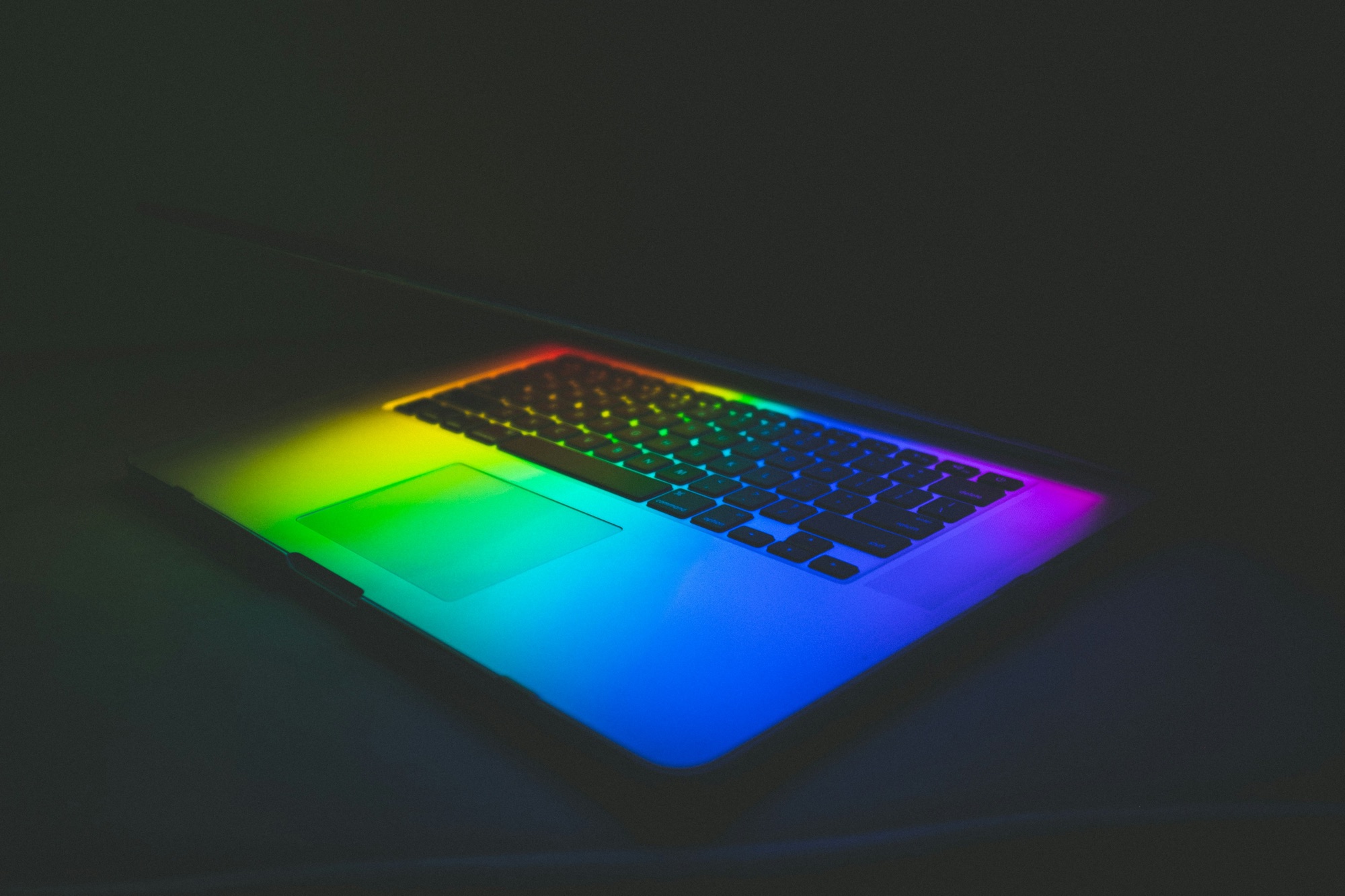 Laptop glowing with a full spectrum of color in the dark, representing an AI harness for law firms